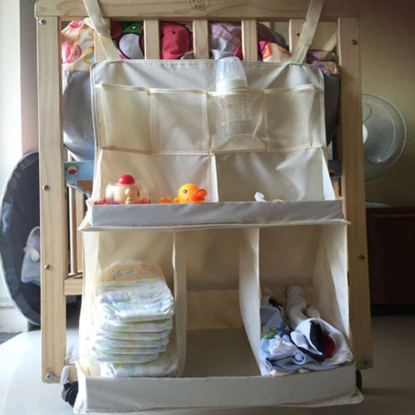 Rangement des affaires bébé dans étagères à suspendre à la table à langer