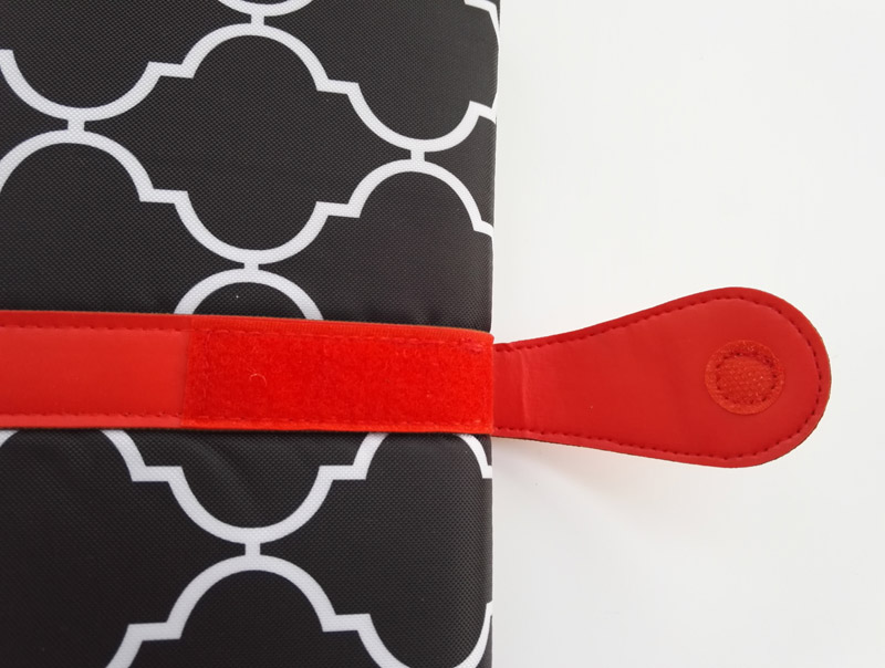 Fermeture à bouton du tapis à langer de voyage