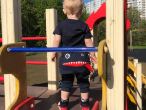 Bébé avec son pantalon de survêtement dans le parc pour enfants