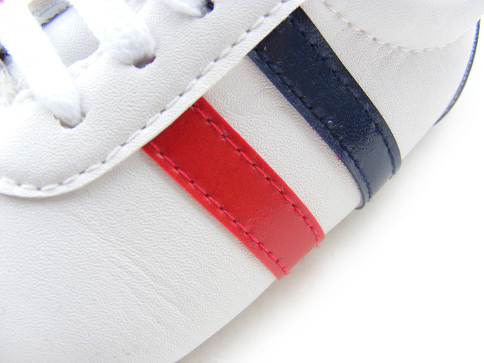 Détail des bandes en bleu et rouge des Baskets blanches